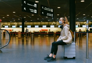 Femme assise sur son bagage à l'aéroport